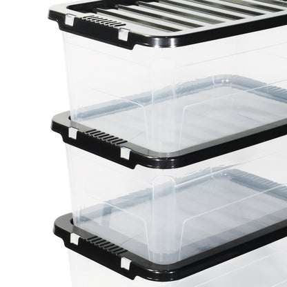 Stack of clear storage bins with black lids on a white background